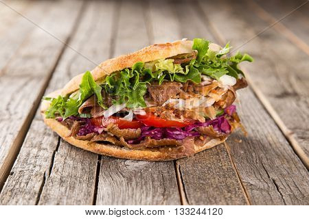close up of kebab sandwich on wooden background