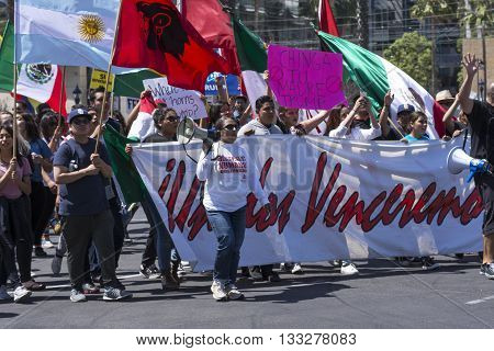 SAN DIEGO USA - MAY 27 2016: Hispanics against Donald Trump march behind a banner of unity outside a Trump rally in San Diego.