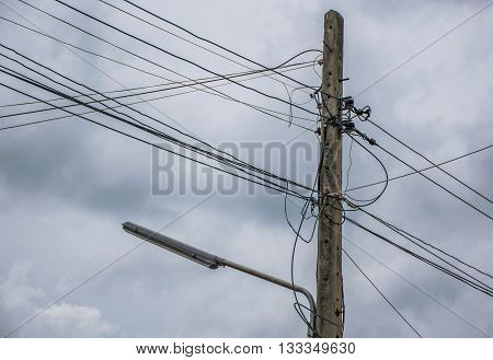 Electricity pole and street light complicated wiring With Dark Storm Clouds