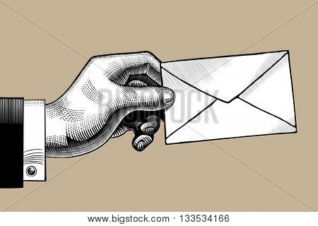 Hand with a Postal envelope. Hand with a mail. Retro style mail sign and icon. Vintage engraving stylized drawing. Vector illustration