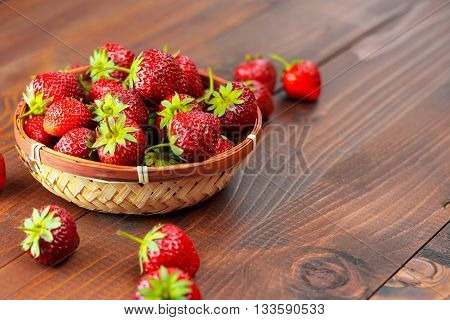 Very Beautiful Background With Fresh Strawberries In A Wicker Round Osier Basket On Old Brown Wooden