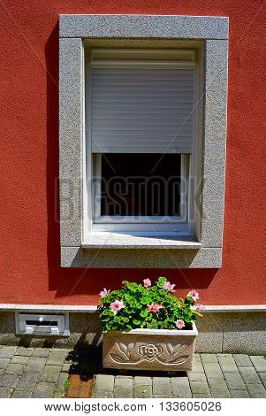 Window with a grey frame on the red wall