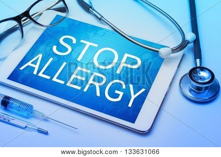 Stop allergy word on tablet screen with medical equipment on background