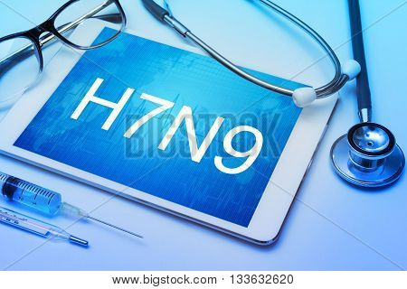 H7N9 word on tablet screen with medical equipment on background