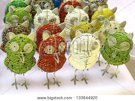 African traditional ethnic colorful bead wire toys animal bird owl on white background. Craftsmanship. South Africa. Local craft market. Artistic retouching.