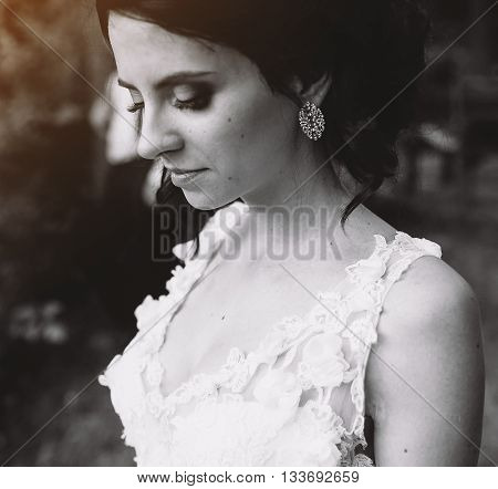 bride looks somewhere in the background is the groom
