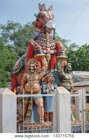 Chettinad India - October 17 2013: Kothamangalam Ayyanar horse shrine. Ayyanar in white and black avatars and supporting his red horse. Figure between them is sponsor of statue.