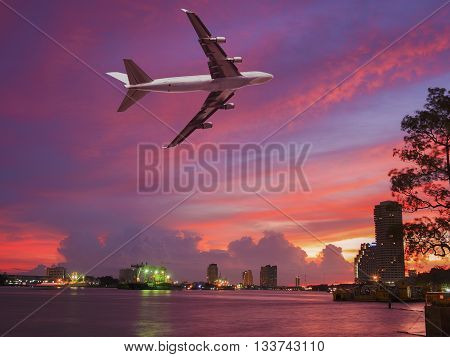 transportation via airplane and shiping on colorful cloudscape on the river side of city skyline