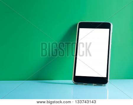 still life shot on smart phone touch screen mobile phone on green background