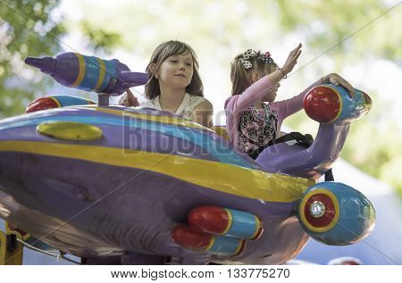 Rostov-on-Don Russia- May 29 2016:Two girls with admiration go for a drive on the carousel in the park named after Ostrovsky