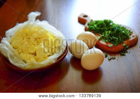 Tilt shift - Homemade cottage cheese in cheesecloth with homemade eggs and fresh herbs
