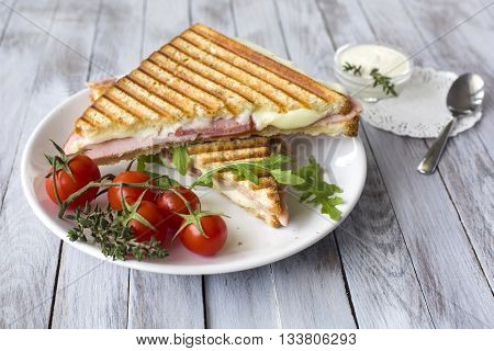 Sandwich with ham and tomatoes on wood background