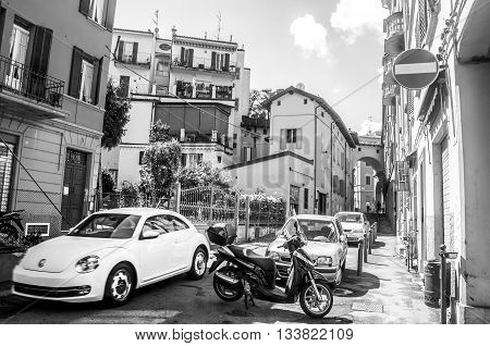 Bologna Italy April 25 2015 - A white beetle car cross a narrow street