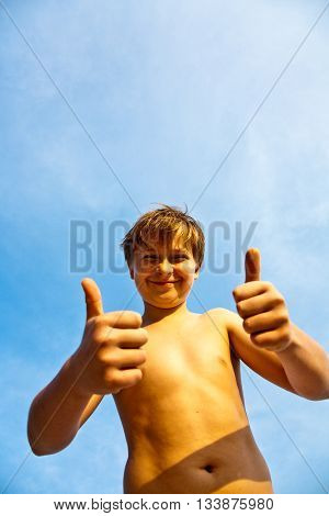 Happy Smiling Young Boy With Background Blue Sky Gives Fingersign