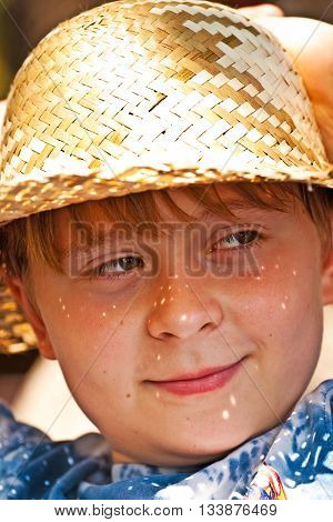 Young Boy With Straw Hat Is Happy And Smiles