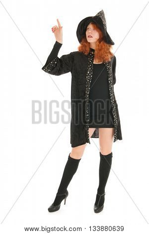 Young woman with red hair as evil witch pointing with finger isolated over white background