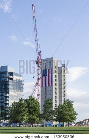 Boston Massachusetts USA - June 9 2016: Huge American flag adorns buildings under construction along Harborwalk in South Boston