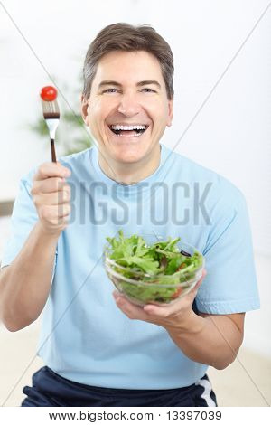 Matura sorridente uomo mangiare insalata, frutta e verdura.