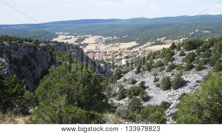 Hilly landscapes with cultivated fields , rocks and forests.
