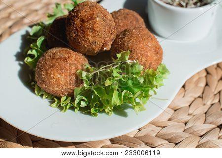 Closeup Of White Plate With Spanish Croquettes With Veal Meat And Mushrooms Served With Salad And Sa
