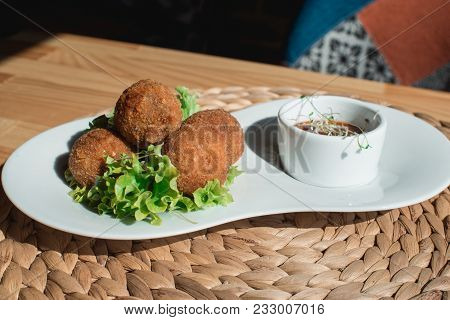 Closeup Of White Plate With Spanish Croquettes With Veal Meat And Mushrooms Served With Salad And Sa