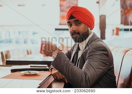 Indian Businessman In A Cafe Taking A Coffee