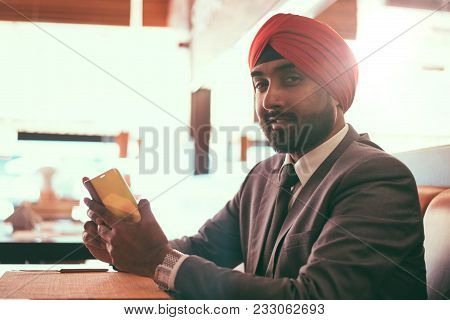 Indian Businessman In A Cafe Taking A Coffee