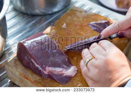 Chef Slices Raw Liver On A Cutting Board
