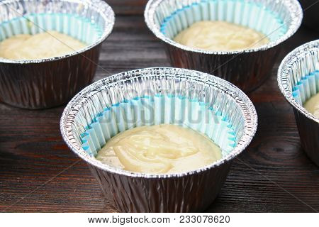 Dough In Molds For Muffins On A Wooden Table