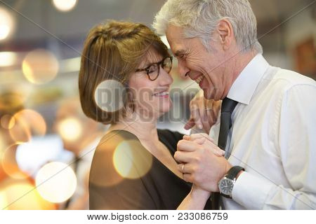 Romantic senior couple dancing together at dance hall