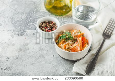 Cabbage Salad With Carrots, Tomatoes And Cucumbers In A Small Pial On A Light Table. Traditional Col