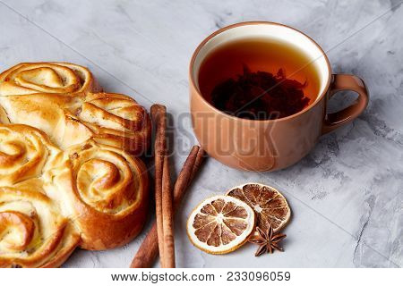Festive Composition Of Homemade Rose Bread With Raisins, Cup Of Tea, Dried Citrus, Anise And Cinnamo