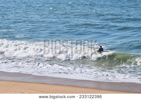 Porto, Portugal - January 31, 2018: Surfer On Ocaen Water In Sunny Day