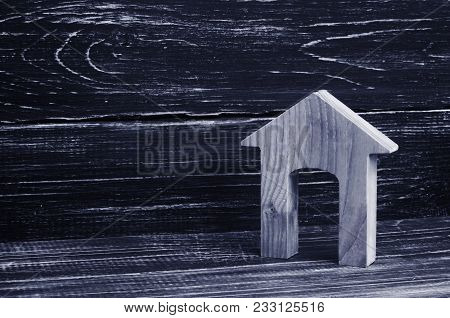 Figurine Of A Wooden House With A Large Doorway On A Background Of Black Boards. Concept Of Real Est
