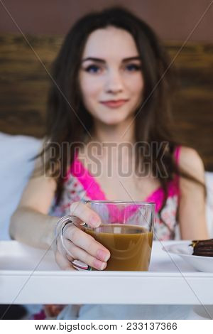 Girl In Bed Holds A Glass Of Coffee