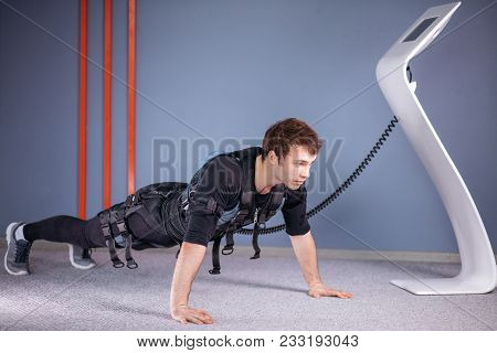 Man In Electrical Muscular Stimulation Suits Doing Plank Exercise. Ems. Workout.