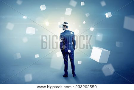Handsome businessman with vr goggle and falling white cubes around