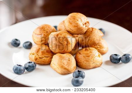 Homemade Profiteroles Served On A White Plate