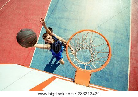 High Angle View Of Basketball Player Dunking Basketball In Hoop.