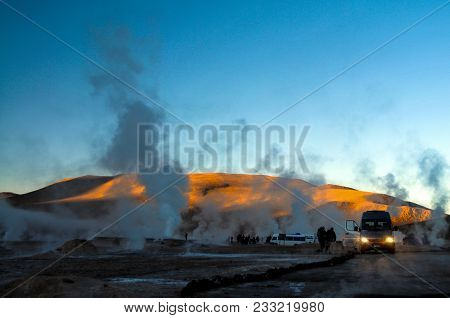 Dec 2010, El Tatio, Atacama Desert, Chile, Steam Of Geyser Against Sun At Sunrise With People Standi