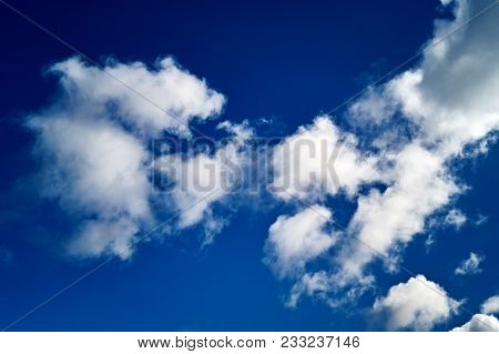 White Clouds In The Sky With Blue Background.