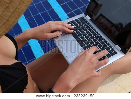 Sexy Girl In A Black Bikini Uses A Laptop With A Black Screen In The Pool.
