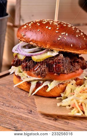 Fresh Homemade Hamburger With Beef, Onion, Sause And Cabbage Garnish On A Wooden Board, Wooden Table