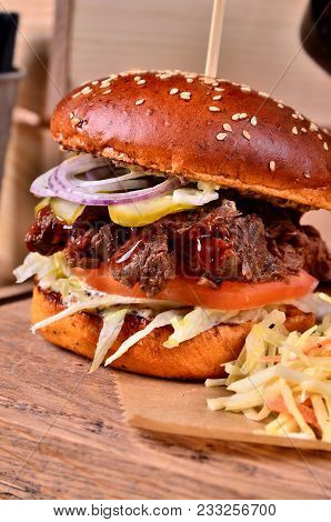 Fresh Homemade Hamburger With Beef, Onion, Sause And Cabbage Garnish On A Wooden Board, Wooden Table