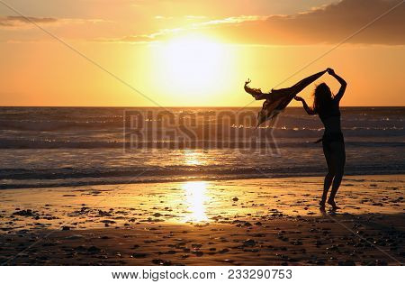 Silhouette Of A Girl At Sunset On The Beach Of The Atlantic Coast In France