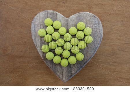 Yellow Tennis Ball Sweets On A Wooden Heart