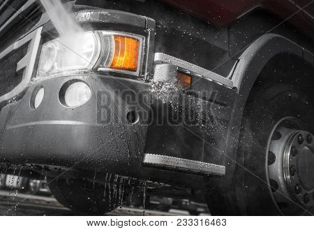 Semi Truck Power Cleaning Closeup Photo. High Pressure Water Jet Cleaning. Heavy Transportation Indu