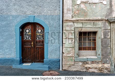 Old Wooden Door Of A Shabby Demaged House Facade. A Small Town In The Mountains Of Slovenia, Europe