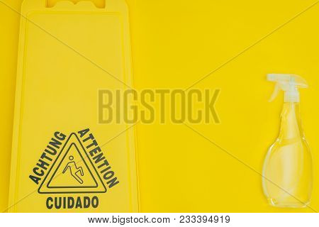 Top View Of Wet Floor Sign And Spray Bottle Isolated On Yellow