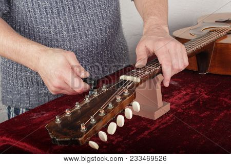 Musical Instrument Guitar Repair And Service - Worker Fix New Strings.